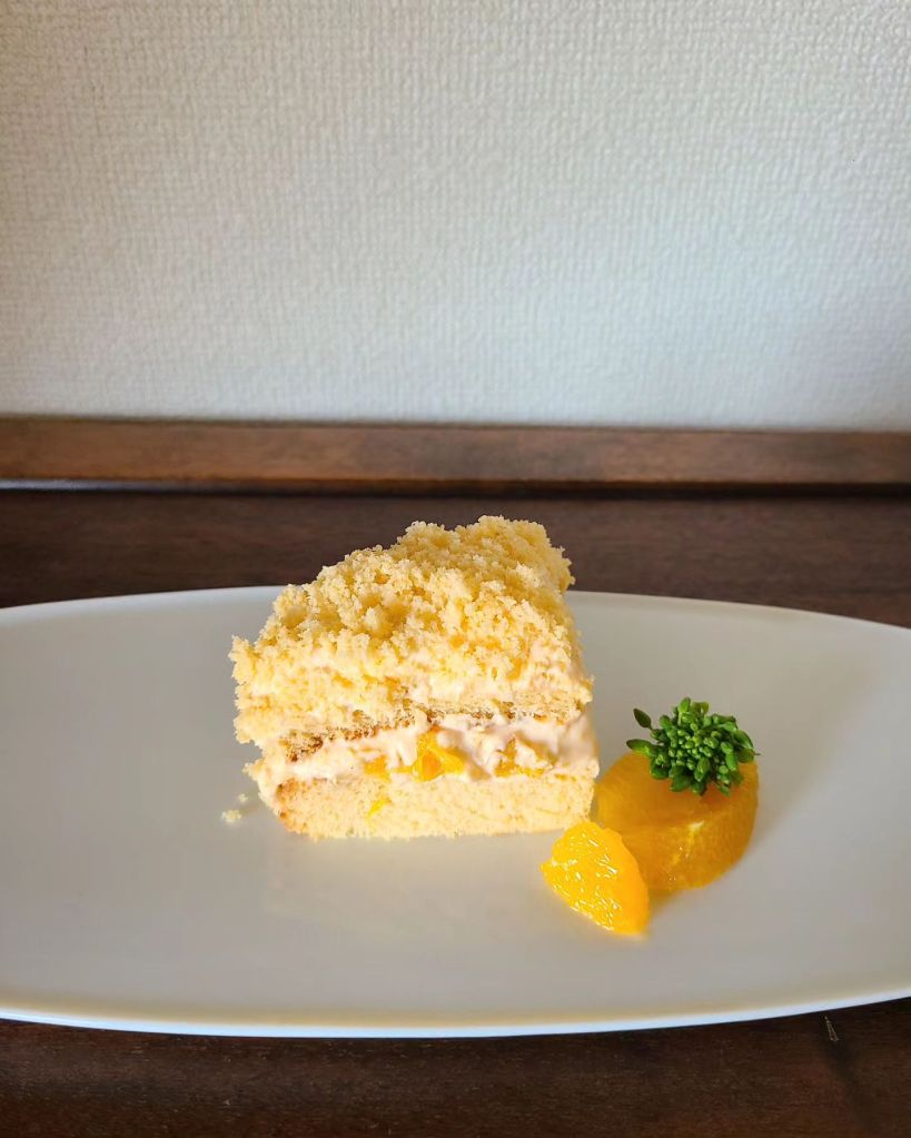 白皿の上にカットしたミモザケーキとオレンジを盛り付け